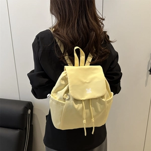 Minimalist light yellow drawstring backpack in waterproof nylon with a flip-top closure