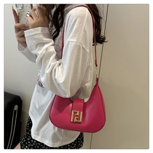 Detail of fuchsia leather hobo bag featuring a geometric gold metal buckle and smooth finish