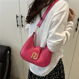 Pink crescent hobo bag with gold geometric buckle worn over the shoulder in a lifestyle shot