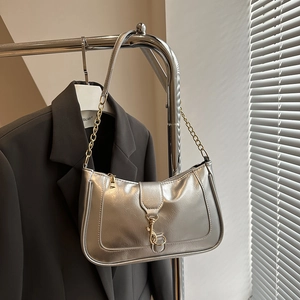 Detail of silver metallic shoulder bag with gold chain and vintage metal buckle closure