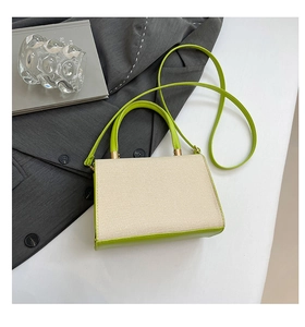 Detail of a green and cream small square bag styled over a classic grey blazer jacket