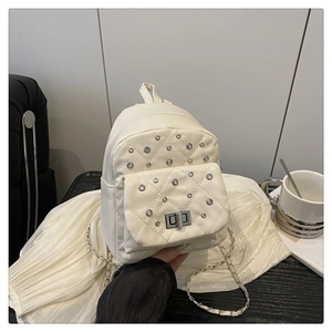 Close-up of cream quilted mini backpack with diamond-encrusted accents and metal lock