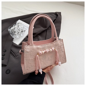 Close-up of pink lace handbag featuring traditional Chinese knots and pearl bead details