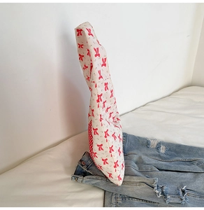 Détail du sac cabas en coton blanc avec motifs nœuds rouges et panneau latéral à carreaux