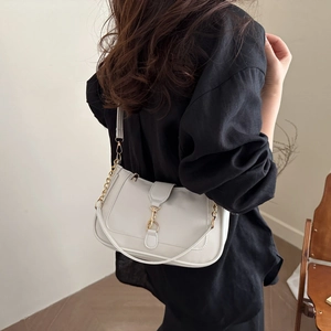 Minimalist light grey leather crescent shoulder bag with elegant gold metal chain and buckle