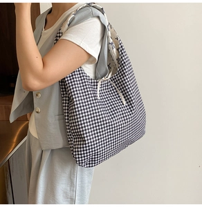 Détail d'un sac cabas à carreaux avec cordon de serrage et doublure à motif nœud