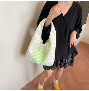 Détail d'un sac cabas floral avec motifs de nœuds verts et poche avant vichy
