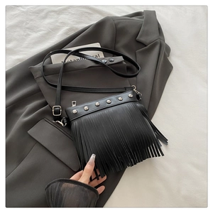 Detail of bohemian black fringe tote bag featuring silver studs and leather tassels