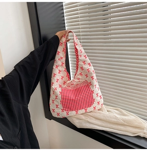 Détail de la poche à carreaux rouges et motif nœud sur le sac fourre-tout en toile