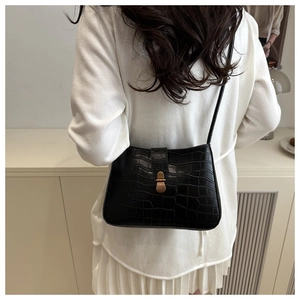 Détail du cuir synthétique noir à motif crocodile avec une boucle dorée rétro