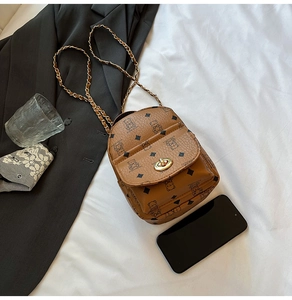 Detailed macro view of mini brown crossbody bag featuring bear print and gold chain strap