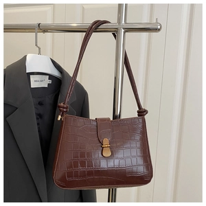 Détail du sac à bandoulière marron foncé texture crocodile avec fermoir doré rétro