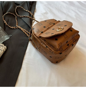 Detail of bear and diamond pattern on brown PU leather bag with golden chain strap