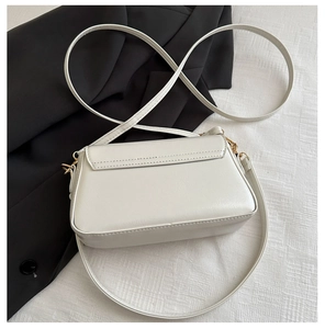 Détail du petit sac bandoulière blanc avec ferrures dorées et bandoulière fine