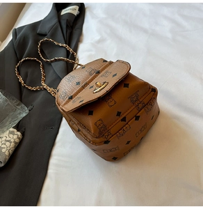 Detail of vintage brown pebble leather backpack with bear print and gold chain