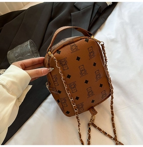 Detail of vintage brown shoulder bag with teddy bear pattern and metal chain strap