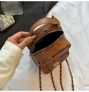Detail view of mini brown PU leather bag with bear print, golden chain and double zippers