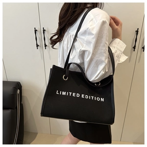 Detail of black canvas tote bag showing LIMITED EDITION print and silver metal grommets