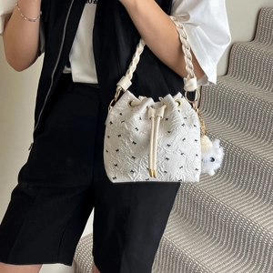 Borsa a secchiello bianca con fiocchi neri e manico intrecciato su modella