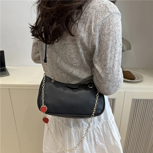 Minimalist black crescent baguette bag with strawberry charms and gold chain strap