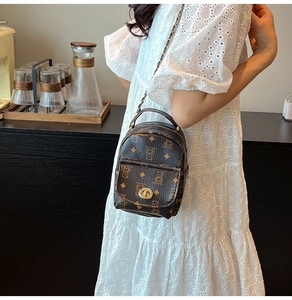Detail of vintage brown monogram mini backpack with gold twist lock and chain strap