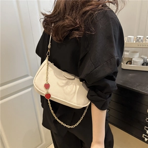 Chic beige grainy leather baguette bag with gold chain and red strawberry charms