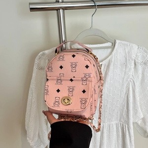 Detailed shot of pink mini backpack with bear pattern and golden twist lock