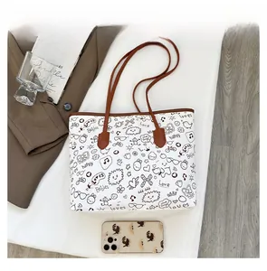 Close-up of graffiti canvas tote with leather straps showing scale versus a smartphone