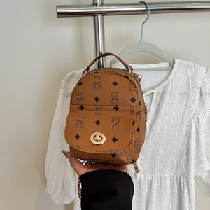 Detail of bear print and golden twist lock on a vintage brown mini backpack purse