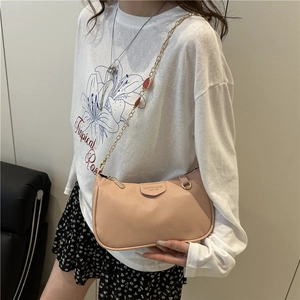 Minimalist nude pink baguette bag in pebble leather with gold chain and drop charm