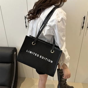Large black canvas tote bag with Limited Edition print shown on a female model