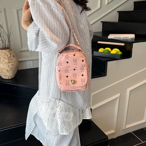 Pink PU leather backpack with vintage bear print and golden chain strap on a model