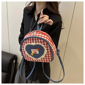 Detail of red checkered mini backpack with lace heart patch and Sweet Cherry label