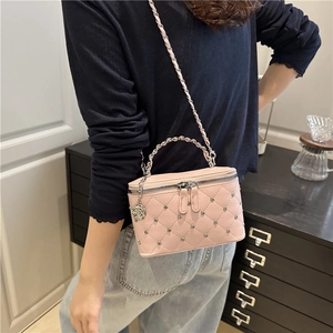 Pink quilted vanity case bag with metallic studs, silver chain strap and rose charm detail