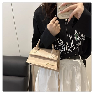 Beige kleine Trapez-Handtasche aus Kunstleder mit goldenem Logo im Lifestyle-Spiegelselfie