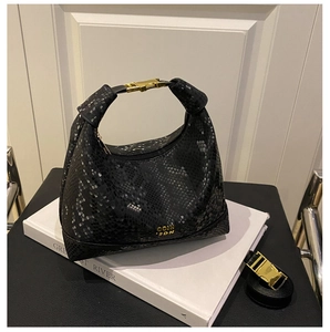 Detail of black snake pattern hobo bag with gold metal buckle and leather texture