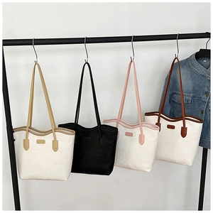 Detail view of large tote bags featuring embossed patterns and long shoulder straps