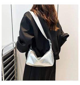 Silberne Metallic Hobo-Schultertasche am Modell mit breitem Gurt und modernem Look