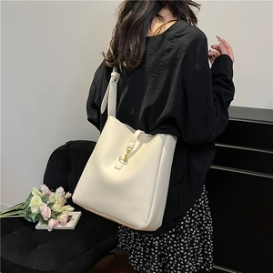 Minimalist cream white bucket bag with golden metal hook and wide adjustable shoulder strap