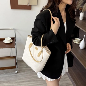 Chic cream tote bag with heart embossing and tan handles for casual office commute style