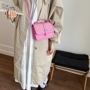 Pink woven fabric and leather satchel bag with silver buckle worn by model