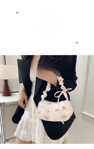 Detail of white floral handbag with pink rose patterns and stylish ruched handle