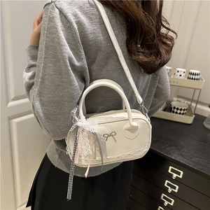 Summer white lace mini bowling bag with bow and ribbon decoration, worn by a model