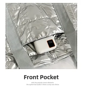 Detail einer silbernen Stepptasche mit Vordertasche, die eine Powerbank enthält