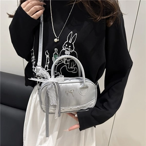 Silver mini bowling bag with lace trim and bow charm, styled with a casual outfit