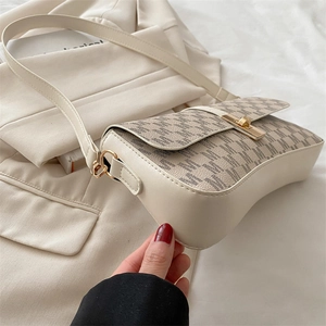 Détail du sac à bandoulière en cuir crème avec rabat à motif M et fermoir doré