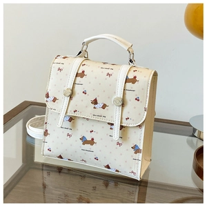 Détail d'un mini sac à dos crème avec imprimé teckel, cerises et nœuds roses