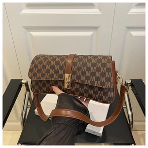 Gros plan du sac porté épaule rétro marron avec motif M et boucle dorée rectangulaire