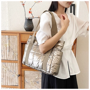 Detail der gesteppten Metallic-Schultertasche mit Rautenmuster und breitem Trageriemen
