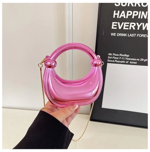 Detail of mini metallic magenta crossbody bag with gold chain strap and curved handle